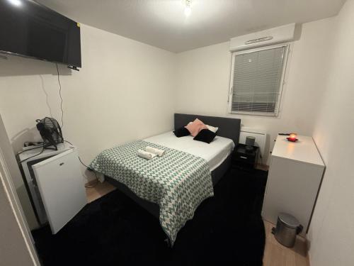 ポーにあるChambre 1の小さなベッドルーム(緑と白の毛布付きのベッド付)