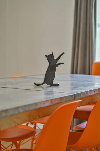 a bat figure sitting on top of a table with orange chairs at Communal Crashpad-City Card for local biz discounts in Oklahoma City