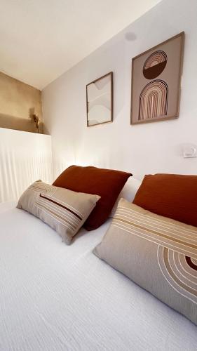 a bedroom with a large white bed with red pillows at La Maison de Victoire et Alix in Pontrieux