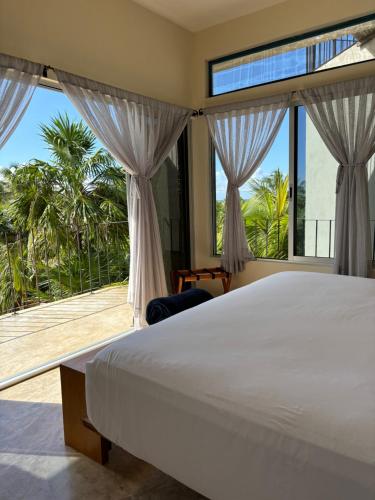 a bedroom with a bed and a large window at Casa Mia El Cuyo Eco Beach Boutique Hotel Sin Aire Acondicionado in El Cuyo
