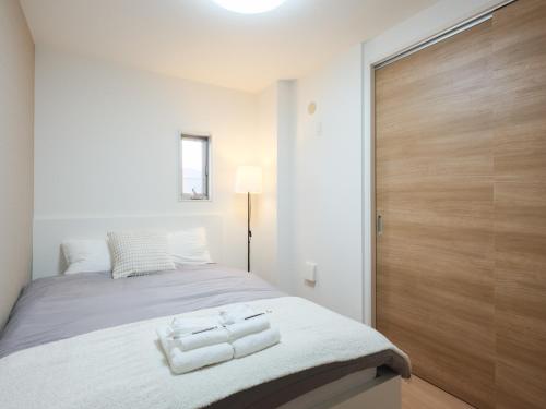 a bedroom with a bed with a wooden door at The River Up Palace - Vacation STAY 19398 in Kisarazu
