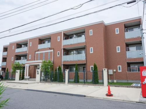 a red brick apartment building with an orange cone in front at The River Up Palace - Vacation STAY 19398 in Kisarazu