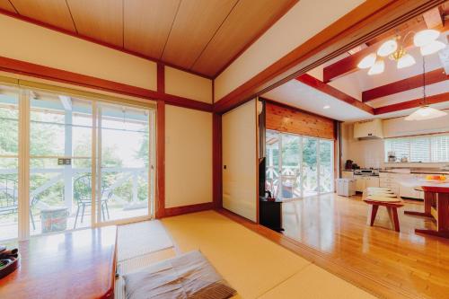 a living room with a large window and a kitchen at Izukogen Yacyonosato Tokiwaso - Vacation STAY 19465 in Ito