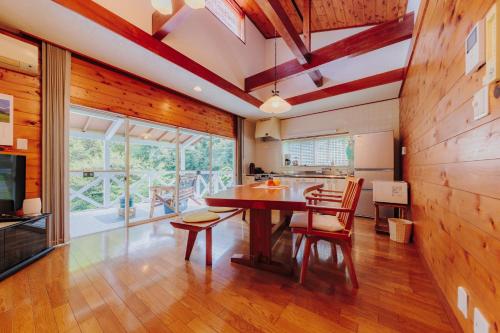 a dining room with a wooden table and chairs at Izukogen Yacyonosato Tokiwaso - Vacation STAY 19465 in Ito