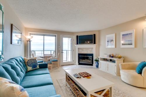 a living room with a blue couch and a fireplace at M & M Beach Nest in Rockaway Beach