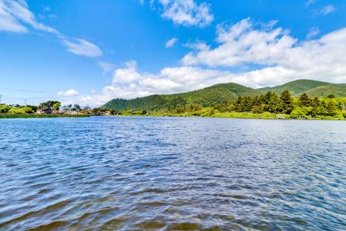 a view of a lake with mountains in the background at M & M Beach Nest in Rockaway Beach
