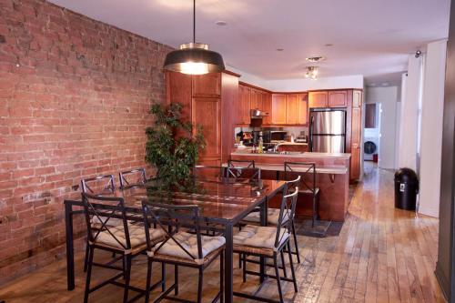 a kitchen with a brick wall and a table and chairs at Le Metro Mont-Royal by HomeInMontreal in Montréal