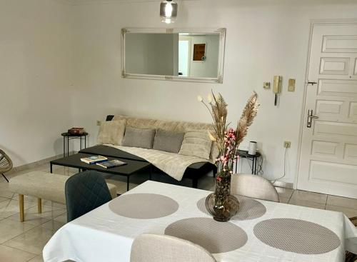 a living room with a table and a couch at Poseidon's Rio Beach Condo in Vernardhaíika