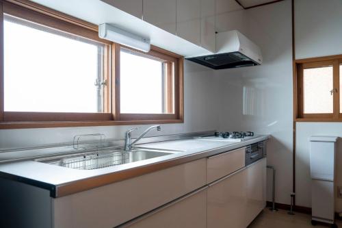 eine Küche mit Spüle und zwei Fenstern in der Unterkunft ETRANA - Vacation STAY 19510 in Sapporo