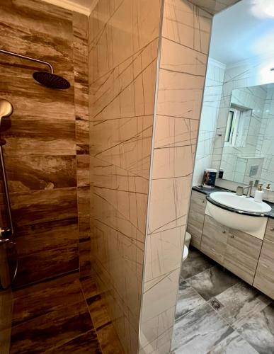 a bathroom with a shower and a sink at Poseidon's Rio Beach Condo in Vernardhaíika