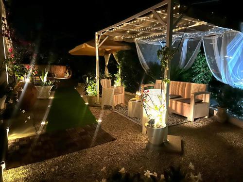 a patio with chairs and an umbrella at night at Villa Rosa in Agropoli