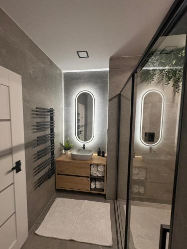 a bathroom with a sink and two mirrors at LUX 3 bedroom apartman in Trenčín