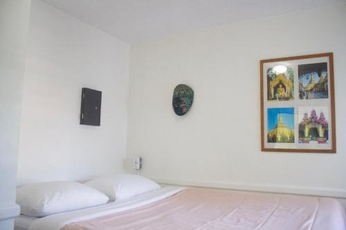 a bedroom with a bed and a clock on the wall at Ocean Island Inn | Backpackers | Suites in Victoria