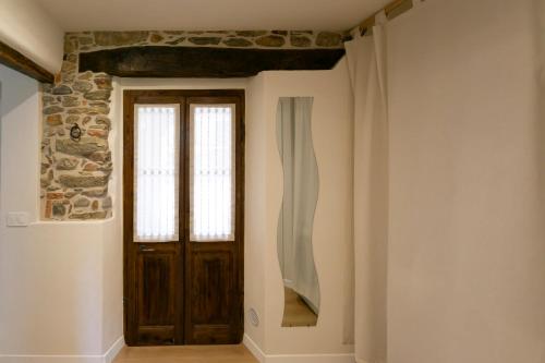 a hallway with a wooden door and a stone wall at Corte di Raglio in Cunardo