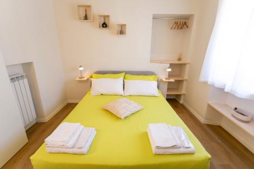 a room with a yellow table with towels on it at Corte di Raglio in Cunardo
