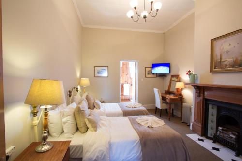 Un dormitorio con una cama grande y una chimenea. en The Nottingham Road Hotel, en Nottingham Road