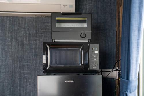 a microwave and a computer on top of a refrigerator at Silk Coat 403 - Vacation STAY 19404 in Chitose
