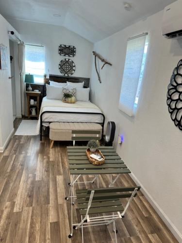 a bedroom with a bed and a wooden floor at Tiny house - Our little piece of paradise in Lakehills
