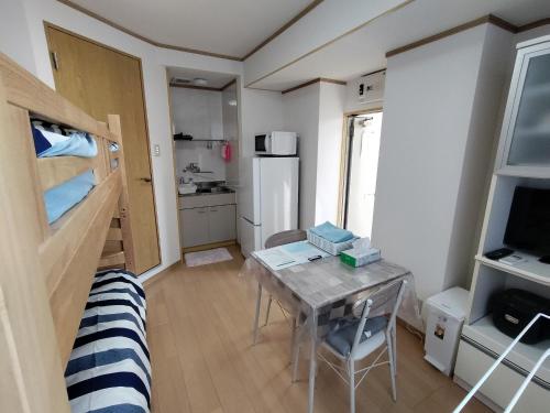 a small room with a table and a refrigerator at Guesthouse Mulberry Kagoshima- Vacation STAY 50746v in Kagoshima