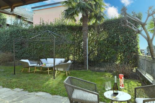 a garden with a table and chairs and a fence at Ca' Lidia - Happy Rentals in Pregassona