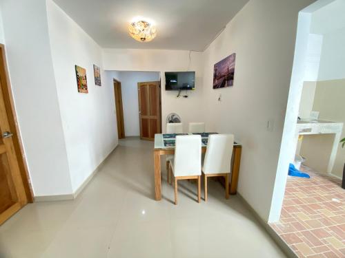 a dining room with a table and white chairs at Apartamento la Isla 2-Coveñas in Coveñas