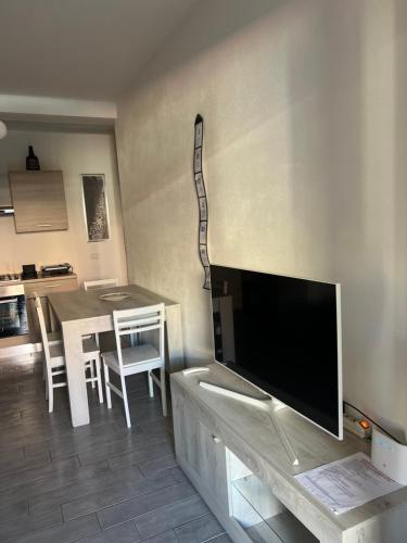 a living room with a television and a table with chairs at Mare Palau Sardegna in Palau