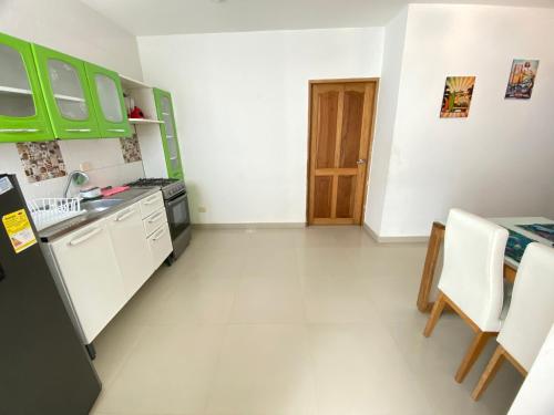 a kitchen with green cabinets and a table at Apartamento la Isla 2-Coveñas in Coveñas