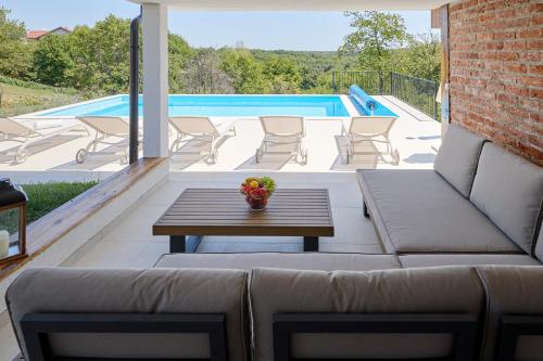 a patio with a couch and a table and a pool at Rustique 1952 in Šiljakovina