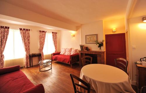 - un salon avec un canapé rouge et une table dans l'établissement Cellier de l'abbaye - L'Ermitage, à Vézelay