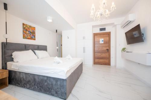 a bedroom with a large bed and a chandelier at Boutique Hotel Kings Palace in Belgrade