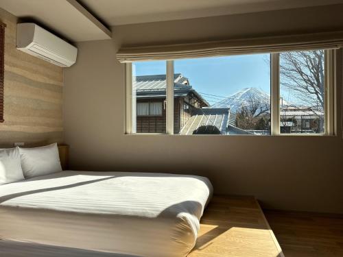 a bedroom with a bed and a large window at Fuji Petel - Vacation STAY 56350v in Azagawa
