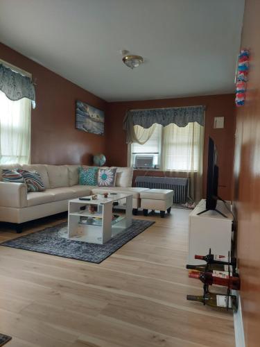 a living room with a couch and a table at Queens chateau in Laurelton