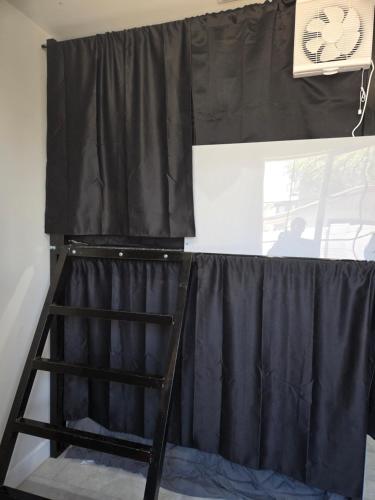 a ladder is standing in front of a black curtain at Casita in back house Not a hotel shared living in Glendale