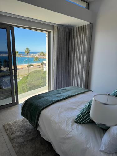a bedroom with a bed with a view of the ocean at Casa de Santos - Bougain Villa in Mossel Bay