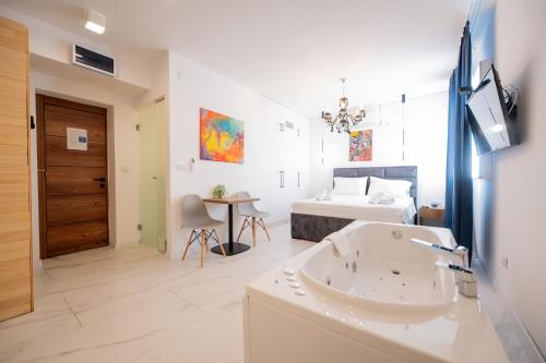 a bathroom with a tub and a bedroom with a bed at Boutique Hotel Kings Palace in Belgrade