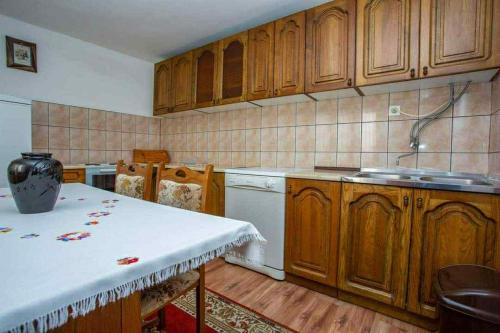 a kitchen with wooden cabinets and a white dishwasher at Apartman Jelena in Soko Banja