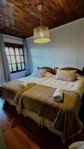 a bedroom with two beds and a chandelier at Hostal Pando in Santa Cruz