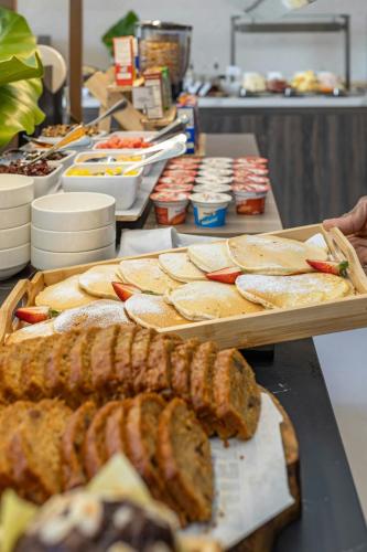 a buffet with bread and sausages and food on a table at AC Hotel by Marriott Punta Cana in Punta Cana