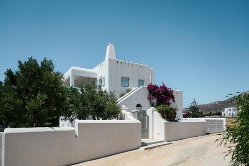 una casa bianca con recinti e alberi bianchi di Naxos Kastraki Homey Villa with Sea View a Kastraki