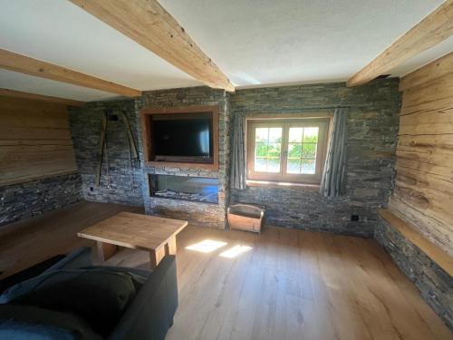 un soggiorno con un tavolo e una TV di Chalet Swissalp Top Flitterwochen, Auszeit, Erholung a Grindelwald