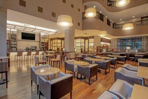 a restaurant with tables and chairs and a bar at Marriott São Paulo Airport Hotel in Guarulhos