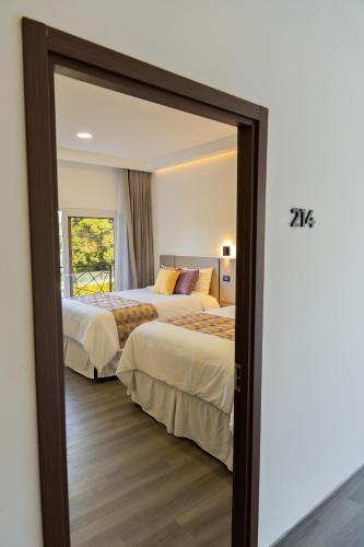 a hotel room with two beds and a mirror at Elithe Hotel in La Esperanza