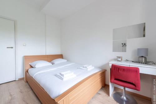 a small bedroom with a bed and a red chair at Jette - Base en peripherie de Ville - 15min Centre in Brussels