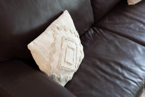 a white pillow sitting on top of a couch at Jette - Base en peripherie de Ville - 15min Centre in Brussels