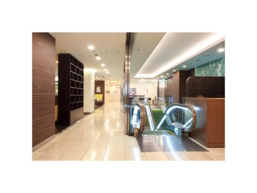 an empty lobby with escalators in a mall at Smile Hotel Sendai Kokubuncho - Vacation STAY 77697v in Sendai