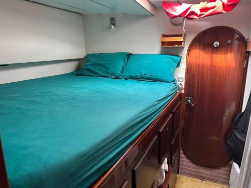 a bed in a small room with a wooden cabinet at Catamaran El Pelegrino in Les Anses-dʼArlets