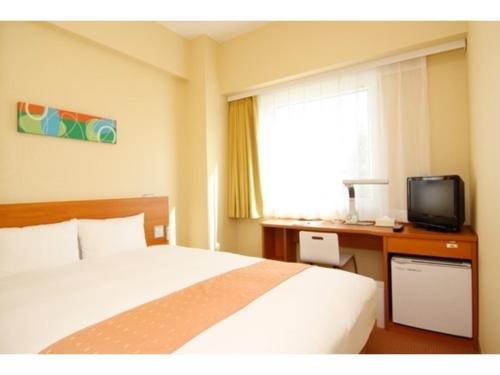 a bedroom with a bed and a desk with a television at Smile Hotel Sendai Izumi Inter - Vacation STAY 77951v in Sendai