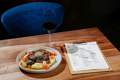 a bowl of pasta and a glass of wine on a table at Courtyard by Marriott Brno in Brno