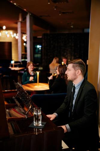 a man in a suit and tie sitting at a table at Courtyard by Marriott Brno in Brno