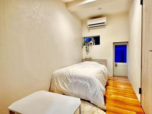 a bedroom with a white bed and a wooden floor at YADORI - Vacation STAY 81027v in Osaka
